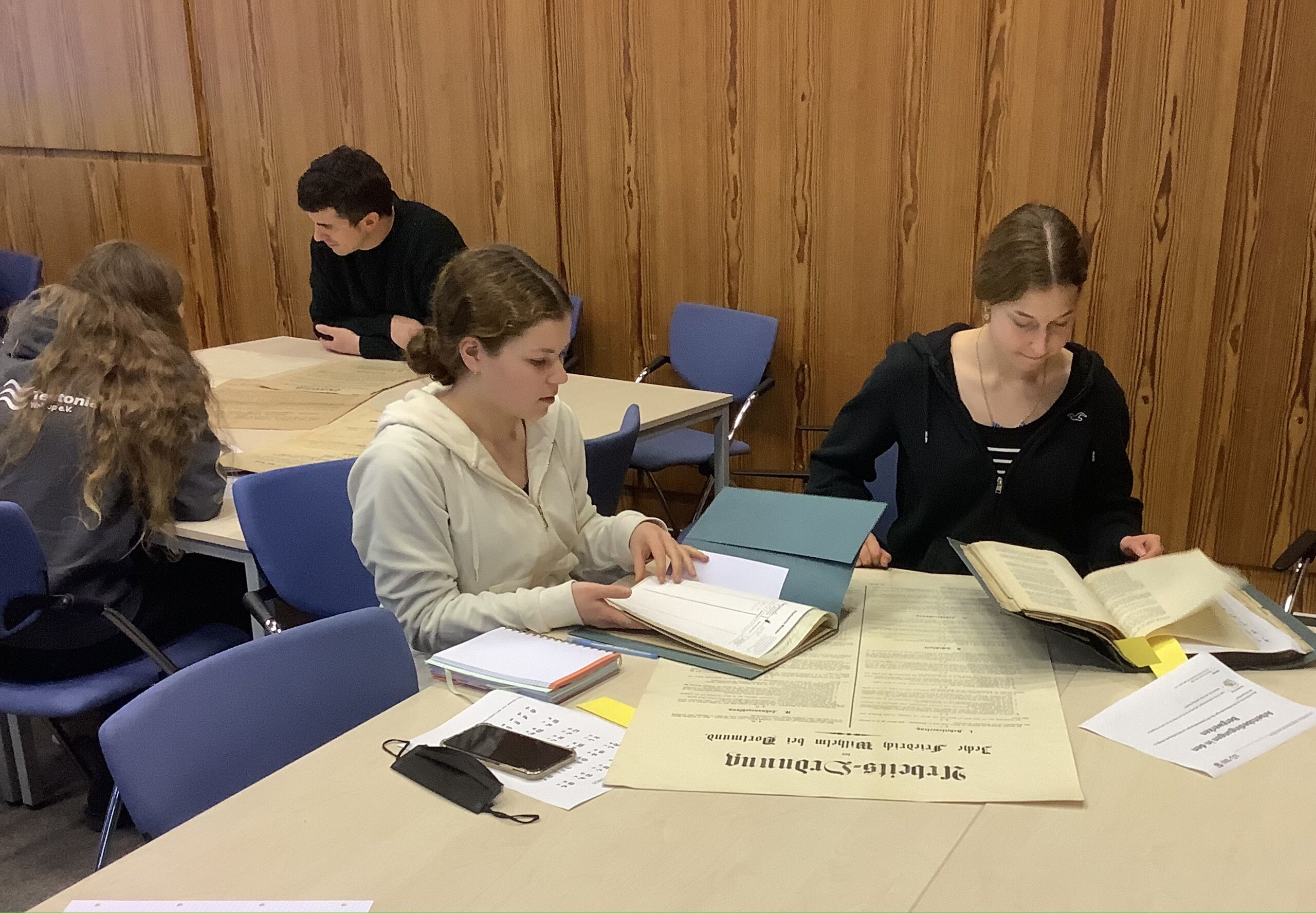 Schüler:innen arbeiten am Plakatmaterial des Landesarchivs in Münster.